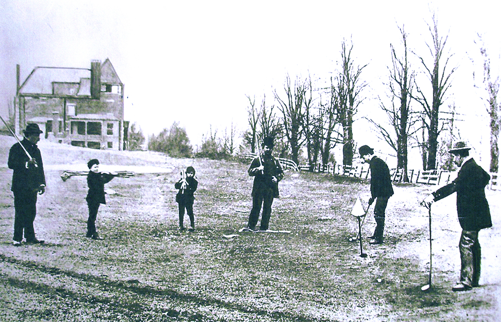 Left to right: Harry Holbrook, Alexander Kinnan and John Reid watch John Upham putting during an early game at Saint Andrew’s Golf Club. Holbrook’s sons, Warren and Fred, are the caddies